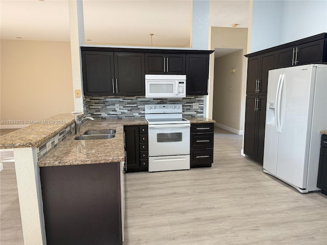 5352 NW 57th Ter, Coral Springs, FL 33067 - kitchen featuring white appliances, a sink, a peninsula, decorative backsplash, and light wood-style floors