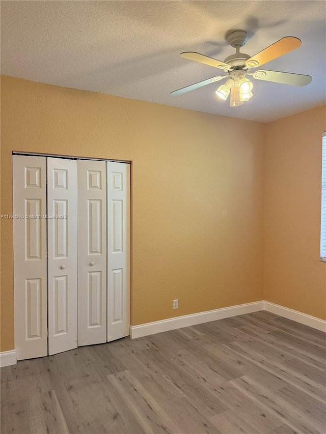5352 NW 57th Ter, Coral Springs, FL 33067 - unfurnished bedroom with wood finished floors, a closet, a ceiling fan, baseboards, and a textured ceiling
