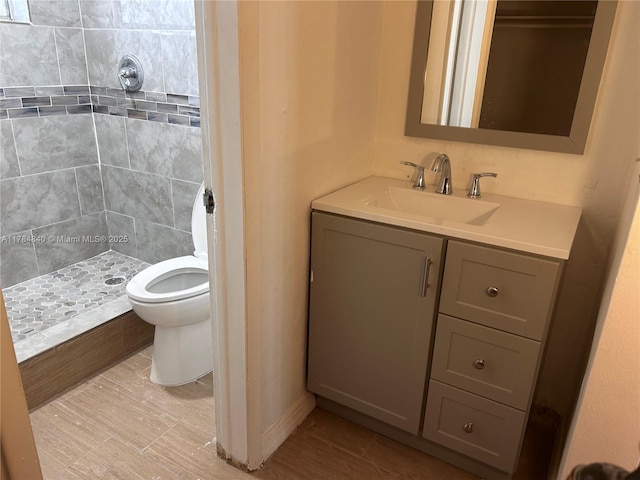 bathroom featuring a shower stall, toilet, and vanity