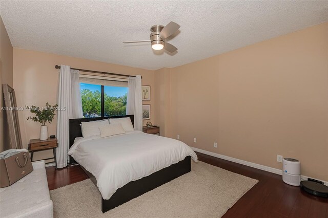 bedroom with wood finished floors, a textured ceiling, baseboards, and ceiling fan