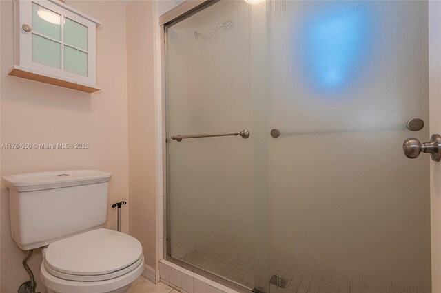full bath featuring a shower stall and toilet