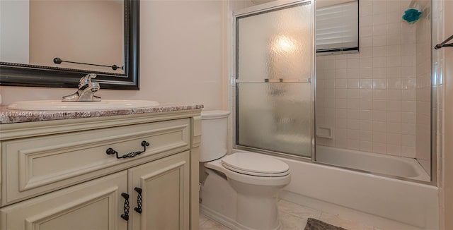 bathroom with toilet, vanity, tile patterned floors, and combined bath / shower with glass door