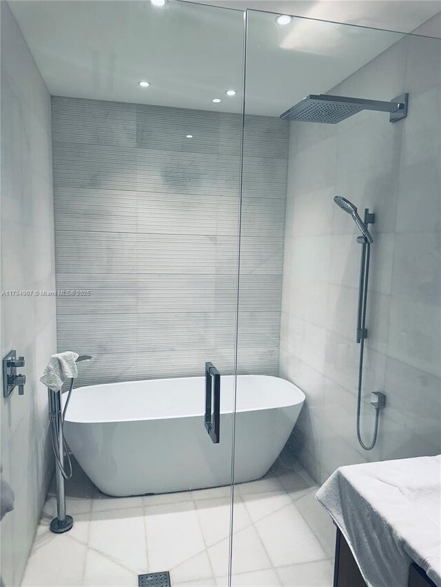 304 Ocean Dr Unit 302, Miami Beach, FL 33139 - full bath with walk in shower, vanity, a soaking tub, tile walls, and recessed lighting