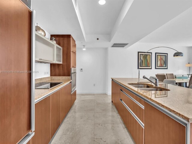 17201 Collins Ave Unit 704, Sunny Isles Beach, FL 33160 - kitchen with a sink, black electric cooktop, stainless steel oven, marble finish floor, and modern cabinets