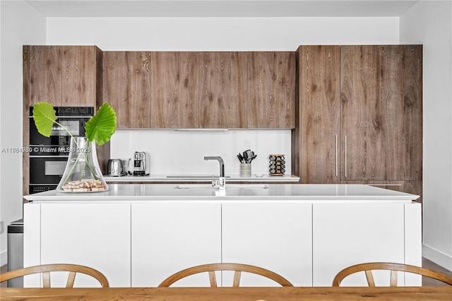650 NE 32nd St Unit Bh6, Miami, FL 33137 - kitchen with modern cabinets, light countertops, black oven, and white cabinets