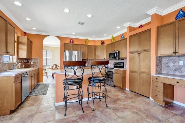16519 SW 54th Ct, Miramar, FL 33027 - kitchen featuring stainless steel appliances, a kitchen bar, decorative backsplash, recessed lighting, and ornamental molding