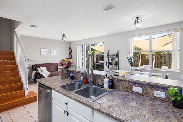 1074 NE 41st Pl, Homestead, FL 33033 - kitchen featuring stainless steel dishwasher, light tile patterned floors, white cabinetry, and open floor plan