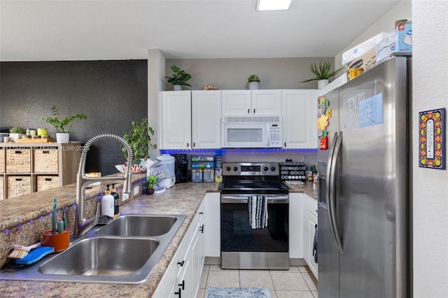 1074 NE 41st Pl, Homestead, FL 33033 - kitchen with appliances with stainless steel finishes, white cabinetry, light tile patterned flooring, and a textured wall