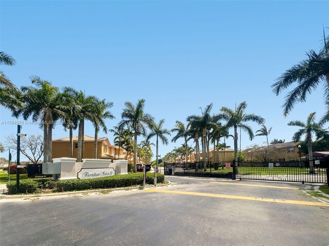 1074 NE 41st Pl, Homestead, FL 33033 - view of asphalt road with a gated entry, curbs, and a gate