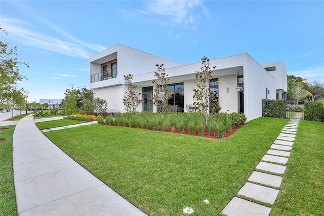 view of property exterior with a lawn, stucco siding, and fence