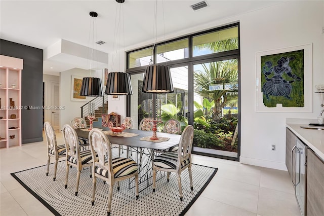 dining room featuring baseboards, light tile patterned flooring, and visible vents