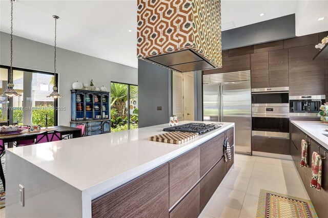 kitchen with light countertops, stainless steel appliances, modern cabinets, and a center island