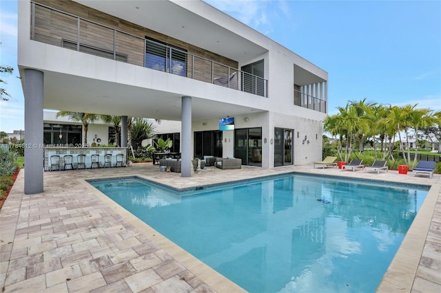 pool with a patio area and outdoor dry bar