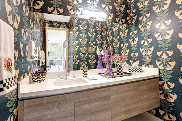 bathroom with vanity and wallpapered walls