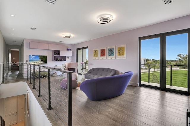 living area featuring visible vents and wood finished floors