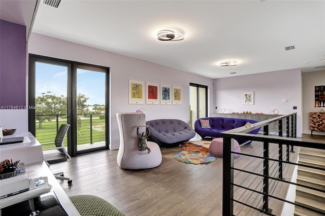 living area with visible vents and wood finished floors