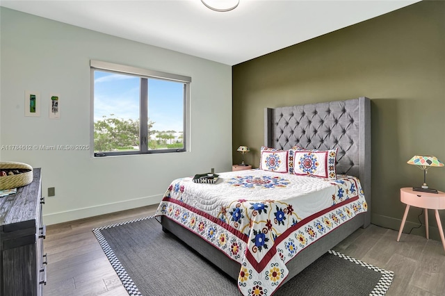 bedroom featuring baseboards and wood finished floors