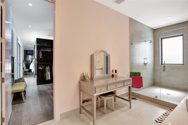 bathroom with baseboards, a shower stall, wood finished floors, and visible vents