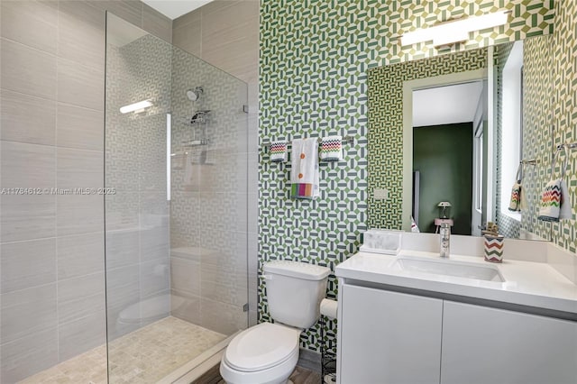 bathroom featuring vanity, toilet, and tiled shower