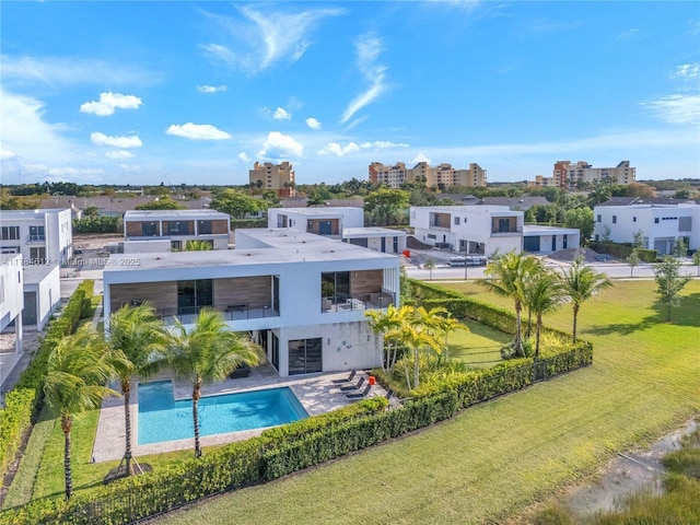 rear view of house featuring a balcony, a fenced backyard, an outdoor pool, stucco siding, and a yard