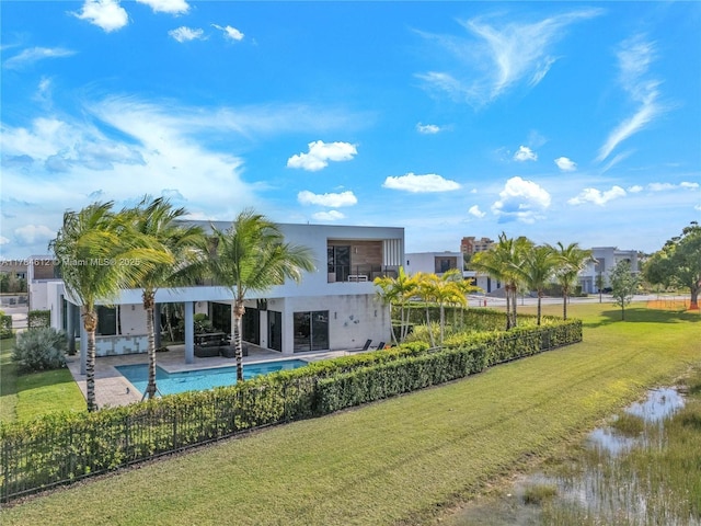 back of house with a lawn, a patio area, fence, a fenced in pool, and stucco siding