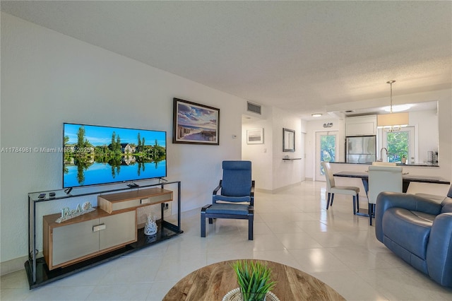 living room with light tile patterned floors, baseboards, and visible vents