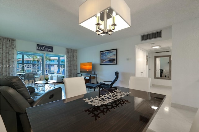 tiled dining room featuring visible vents and a chandelier