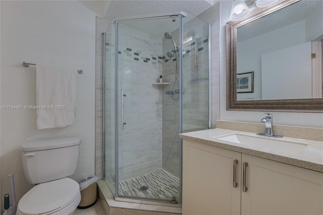 full bath featuring a shower stall, vanity, and toilet