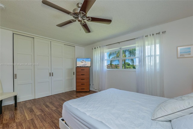 bedroom featuring a ceiling fan, a textured ceiling, a closet, and dark wood finished floors