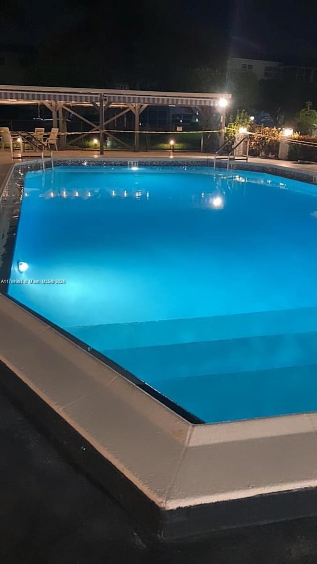view of pool at twilight