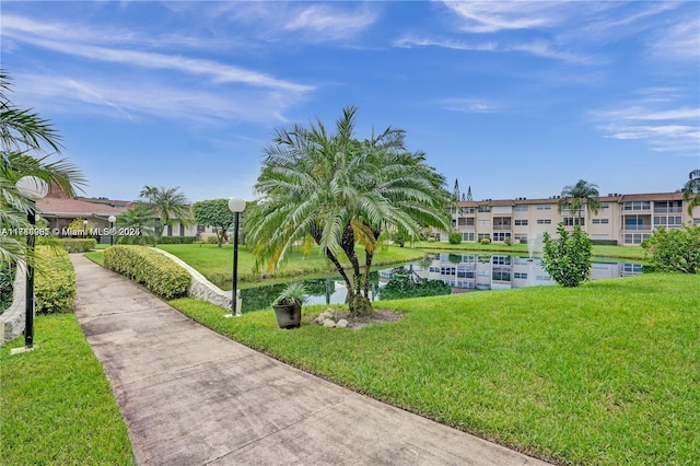 view of home's community featuring a water view and a lawn