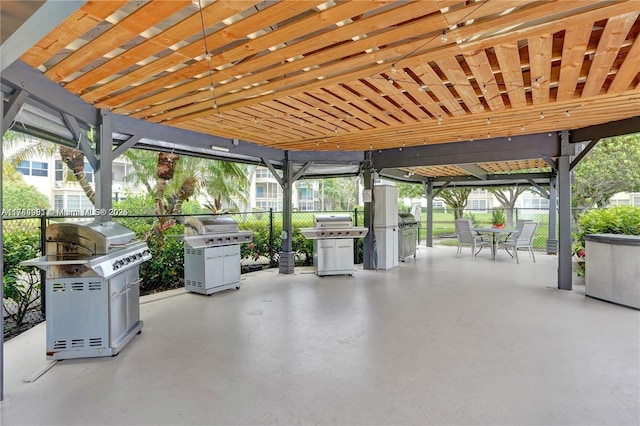 view of patio with area for grilling, outdoor dining space, and fence