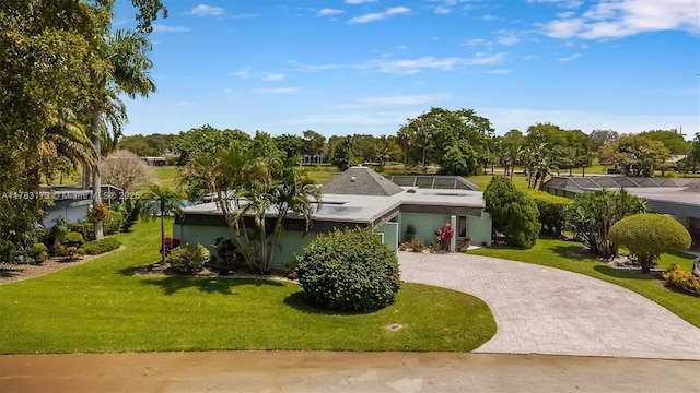 5721 Bayberry Ln, Tamarac, FL 33319 - view of front facade with curved driveway, a front yard, and view of wooded area