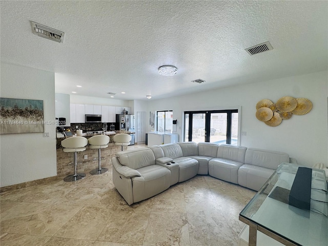 living room featuring a textured ceiling and visible vents