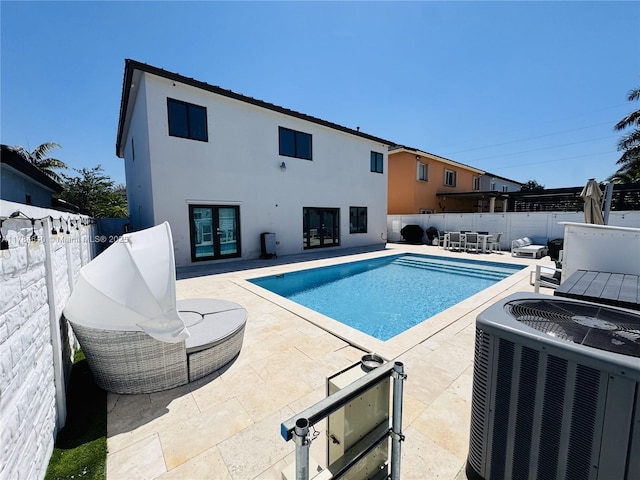 view of swimming pool with central AC, a patio area, a fenced backyard, french doors, and a fenced in pool