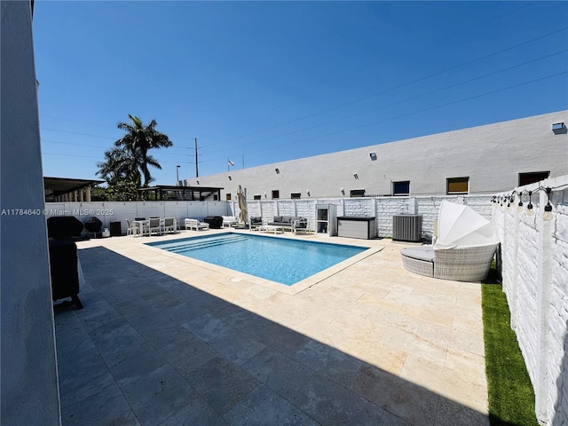 view of pool with a patio area, fence, a fenced in pool, and central air condition unit