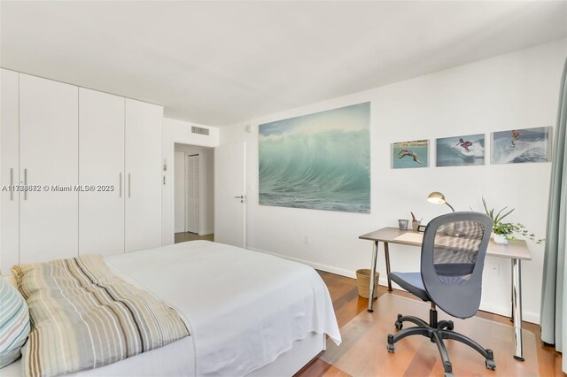 9250 W Bay Harbor Dr Unit 5C, Bay Harbor Islands, FL 33154 - bedroom featuring a closet, visible vents, baseboards, and wood finished floors