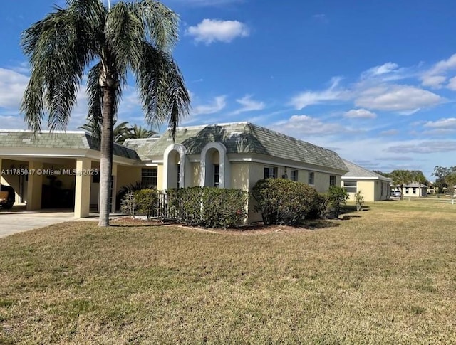 ranch-style home with a carport, concrete driveway, stucco siding, and a front yard