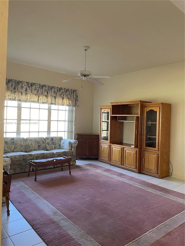 living room with light tile patterned floors, a wealth of natural light, and a ceiling fan