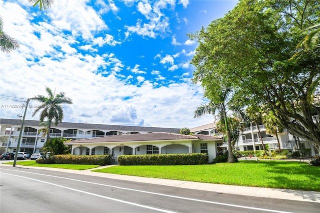 581 Blue Heron Dr Unit 112-B, Hallandale Beach, FL 33009 - view of front facade with a front yard, stucco siding, and a tiled roof
