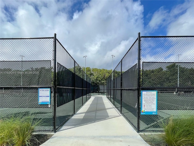 581 Blue Heron Dr Unit 112-B, Hallandale Beach, FL 33009 - view of tennis court with fence and a gate