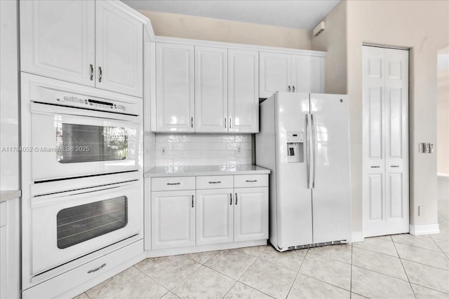 12580 NW 76th St, Parkland, FL 33076 - kitchen with white appliances, white cabinets, light countertops, and tasteful backsplash