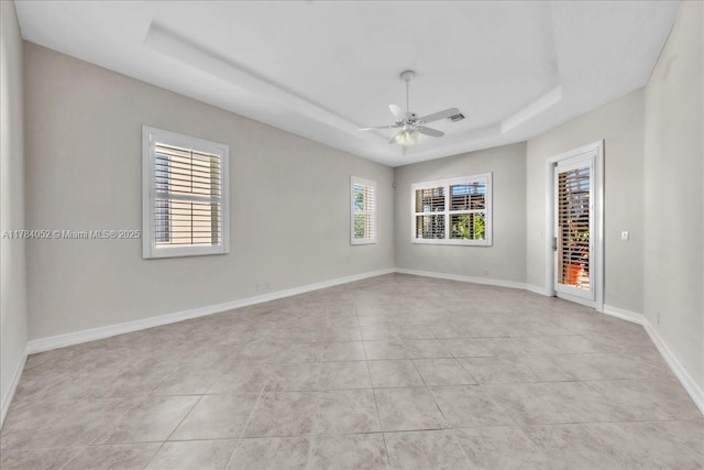 12580 NW 76th St, Parkland, FL 33076 - spare room featuring a tray ceiling, ceiling fan, light tile patterned floors, and baseboards