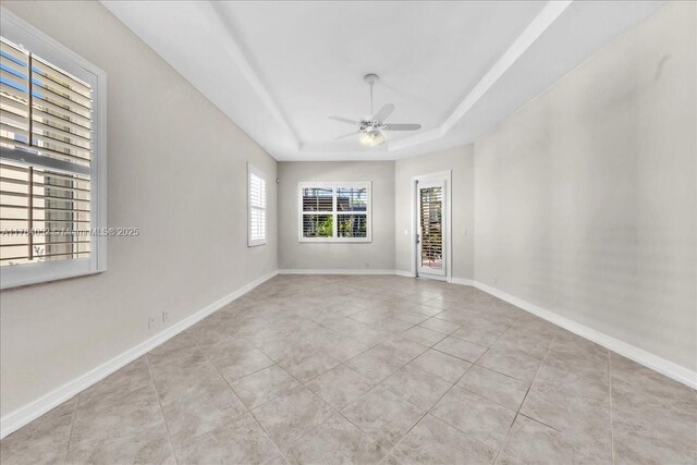 12580 NW 76th St, Parkland, FL 33076 - spare room featuring ceiling fan, tile patterned floors, a tray ceiling, and baseboards