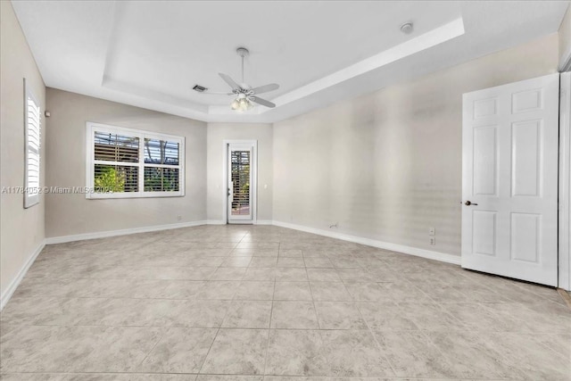 12580 NW 76th St, Parkland, FL 33076 - empty room with a raised ceiling, light tile patterned floors, ceiling fan, and baseboards