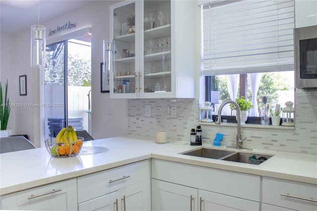 kitchen featuring a sink, tasteful backsplash, and white cabinetry