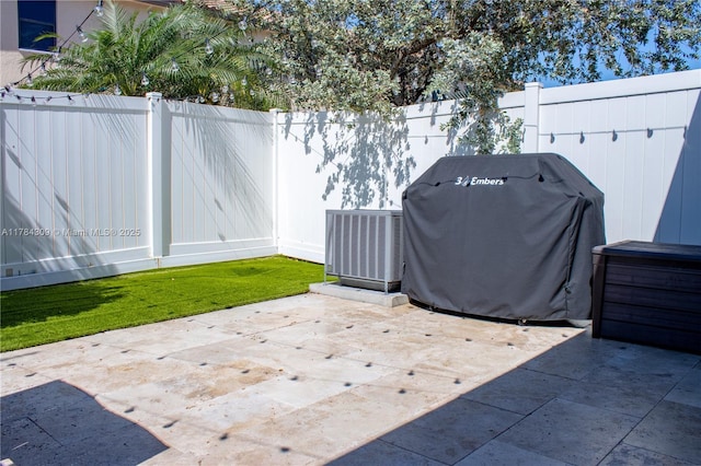 view of patio with grilling area, a fenced backyard, and cooling unit