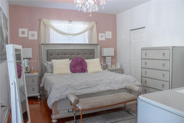 bedroom featuring a notable chandelier and wood finished floors