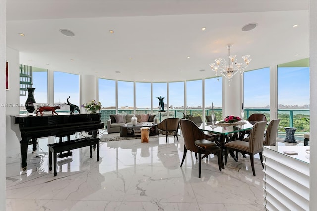 dining area featuring marble finish floor, an inviting chandelier, and a healthy amount of sunlight
