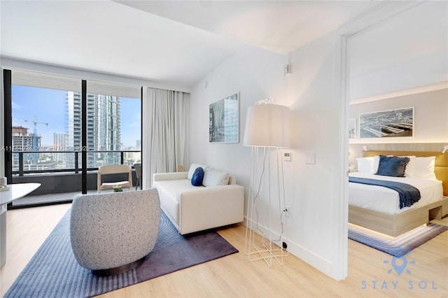 601 NE 1st Ave Unit 1602, Miami, FL 33132 - bedroom featuring a wall of windows, a city view, baseboards, and wood finished floors